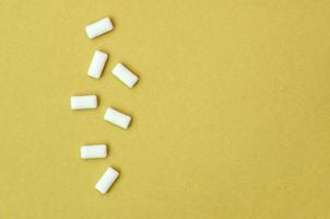 A few chewing gums lie on texture background of fashion pastel orange color paper photo