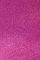 The blanket of furry pink fleece fabric. A background texture of light pink soft plush fleece material photo