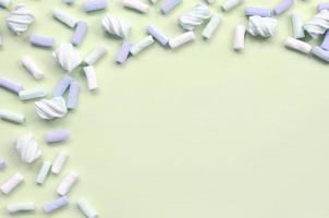 Colorful marshmallow laid out on lime paper background. pastel creative textured framework photo