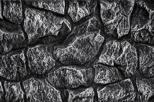 Stone wall background - building feature. Texture of thick and strong wall of rough stones of various shapes and sizes. photo