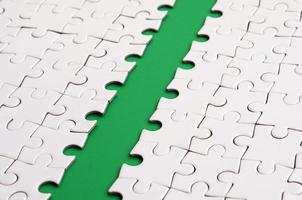 The green path is laid on the platform of a white folded jigsaw puzzle. Texture image with copy space for text photo