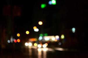 Blurred night scene of traffic on the roadway. Defocused image of cars traveling with luminous headlights. Bokeh Art photo