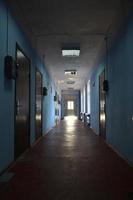 The gloomy corridor of a neglected public building. Public space in a poor residential high-rise building photo