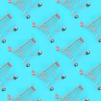 Shopping addiction, shopping lover or shopaholic concept. Many small empty shopping carts perform a pattern on a pastel colored paper background. Flat lay composition, top view photo