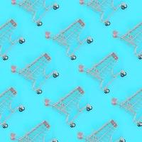 Shopping addiction, shopping lover or shopaholic concept. Many small empty shopping carts perform a pattern on a pastel colored paper background. Flat lay composition, top view photo