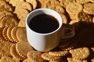 taza de café pequeña y galleta salada foto