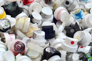 A pattern of many used and soiled nozzles from spray cans with aerosol paint. Background texture of the street art of drawing graffiti on the walls photo