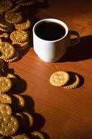 taza de café pequeña y galleta salada foto