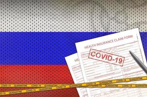 formulario de reclamación de seguro de salud y bandera de rusia con sello covid-19. coronavirus o concepto de virus 2019-ncov foto