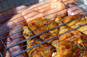 Marinated chicken legs on hot BBQ charcoal field grill photo