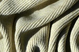 Fabric texture of a soft yellow knitted sweater. Macro image of the structure of bindings in yarns photo