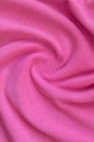 The blanket of furry pink fleece fabric. A background of light pink soft plush fleece material with a lot of relief folds photo