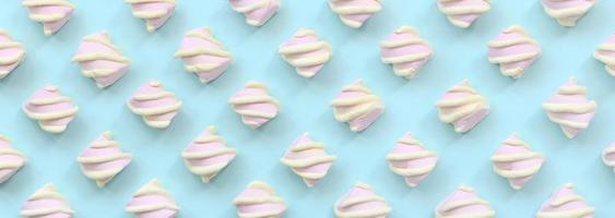 Colorful marshmallow laid out on blue paper background. pastel creative textured pattern. minimal photo