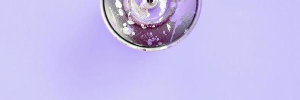 Single used spray can for graffiti drawing lies on a pastel colored backgroung. Street art painting concept. Minimal flat lay. Top view photo