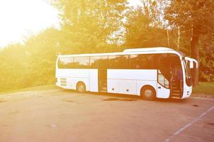 White tourist bus for excursions. The bus is parked in a parking lot near the park photo