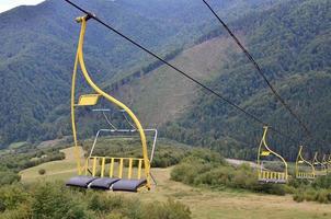 The seats of the cable car on the background of Mount Makovitsa, one of the Carpathian Mountains photo