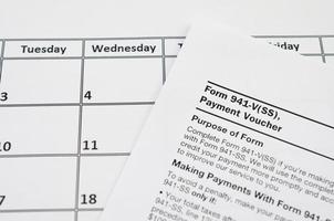 IRS Form 941-V Payment Voucher blank lies on empty calendar page photo