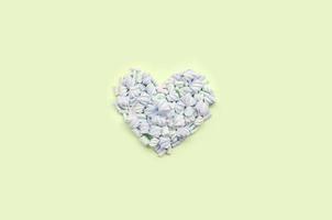 Colorful marshmallow laid out on lime and pink paper background. pastel creative textured heart photo