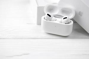 KHARKIV, UKRAINE - JANUARY 27, 2021 Apple AirPods Pro on a white background. Wireless headphones with charging case and a box. Apple Inc. is an American technology company photo