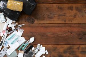 A lot of narcotic substances and devices for the preparation of drugs lie on an old wooden table photo