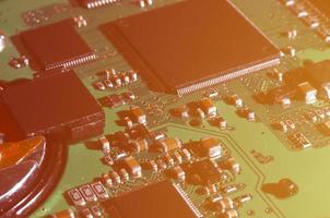 A toned macro image of a computer board with many small technological elements. Extremely shallow depth of field. Abstract technological background photo
