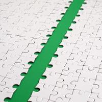 The green path is laid on the platform of a white folded jigsaw puzzle. Texture image with copy space for text photo