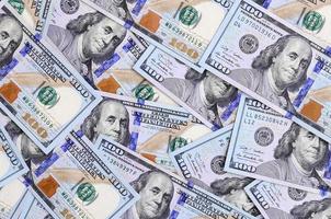 A large number of US dollar bills of a new design with a blue stripe in the middle. Top view photo
