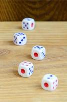 A few dice lies on the surface of natural wood. Items for generating numbers from one to six in the form of points that are painted on the side of cubes. The concept of gambling photo