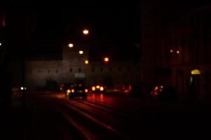 escena nocturna borrosa de tráfico en la carretera. imagen desenfocada de coches que viajan con faros luminosos. arte bokeh foto