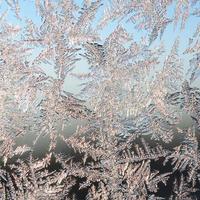 Snowflakes frost rime macro on window glass pane photo