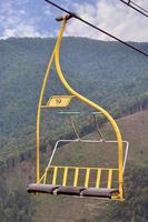 The seats of the cable car on the background of Mount Makovitsa, one of the Carpathian Mountains photo