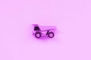 Small purple toy truck on texture background of fashion pastel purple color paper photo