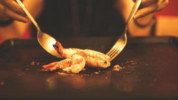 camarones a la parrilla en una sartén caliente con cuchara y tenedor. foto