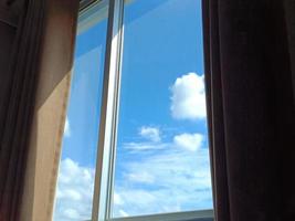 la ventana del dormitorio da al cielo diurno. foto