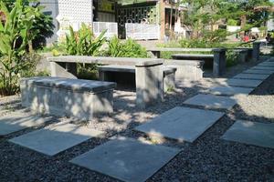 table and chairs made of cement on the side of the road photo