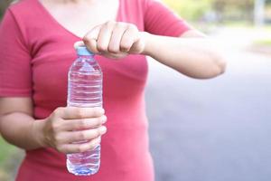 Woman is drinking clean water to refresh the body. photo