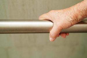 Asian elderly old woman patient use toilet support rail in bathroom, handrail safety grab bar, security in nursing hospital. photo