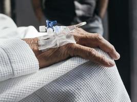 primer plano del tubo de fluidos intravenosos conectado a la mano de un paciente foto