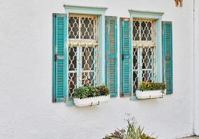 ventanas y persianas de madera pintadas de azul en casa al atardecer foto
