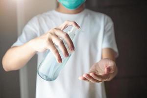hombre que usa gel desinfectante con alcohol para limpiar la mano concepto de prevención del virus corona covid-19 foto
