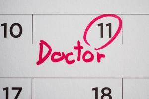 important doctor appointment schedule write on white calendar page date close up photo