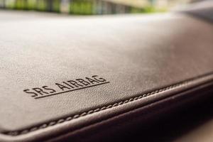 airbag safety sign on brown leather texture in modern car photo