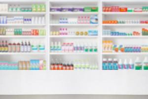 Empty wood counter top with pharmacy drugstore shelves blur pharmaceutical medicine product background photo