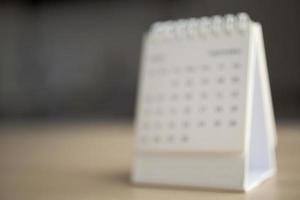 Blur calendar page close up on wood table background business planning appointment meeting concept photo