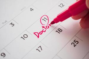 important doctor appointment schedule write on white calendar page date close up photo