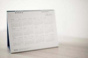 Blur calendar page close up on wood table background business planning appointment meeting concept photo