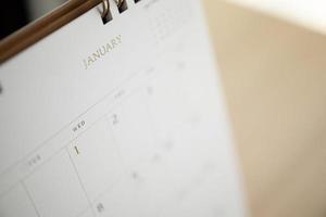 calendar page close up at January on wood table background business planning appointment meeting concept photo