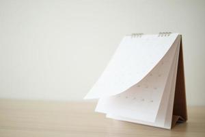 Blur Calendar page flipping sheet on wood table background business schedule planning appointment meeting concept photo