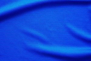 Blue football jersey clothing fabric texture sports wear background, close up top view photo