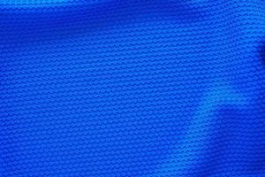 Blue football jersey clothing fabric texture sports wear background, close up top view photo